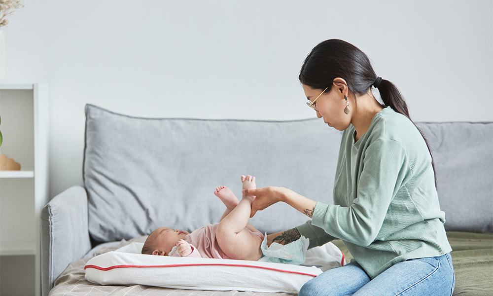Mom changing her baby clothes